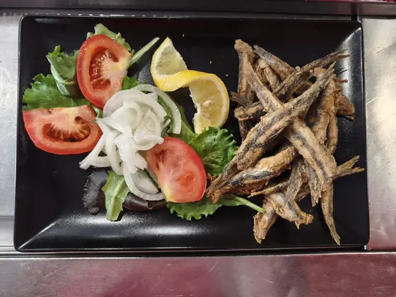Boquerones fritos con ensalada de tomate y cebolla