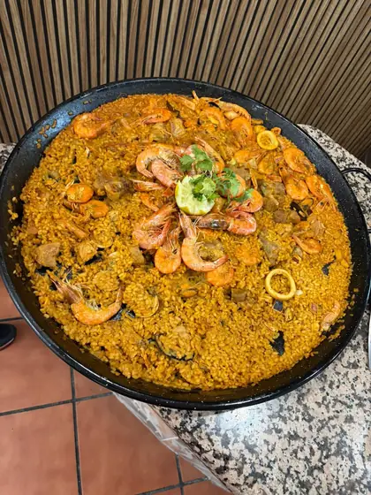 Paellera con arroz amarillo, gambas y calamares