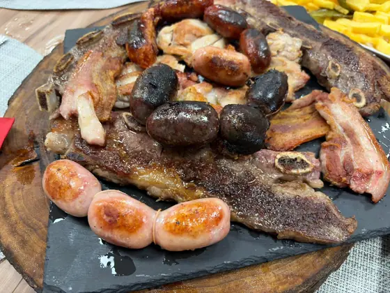 Parrillada con chorizos, morcillas, salchichas, panceta y carne sobre una tabla