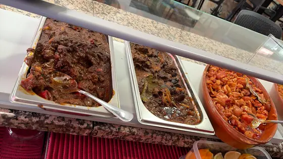 Tres fuentes de guisos caseros en la vitrina de la barra
